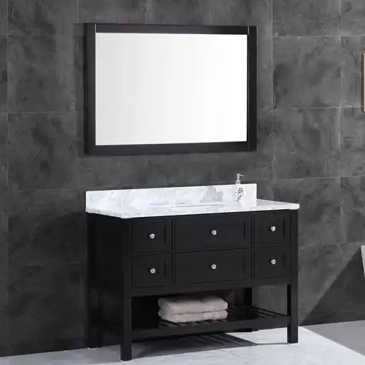 Black bathroom vanity with a white marble countertop, an integrated sink, and an unframed mirror.