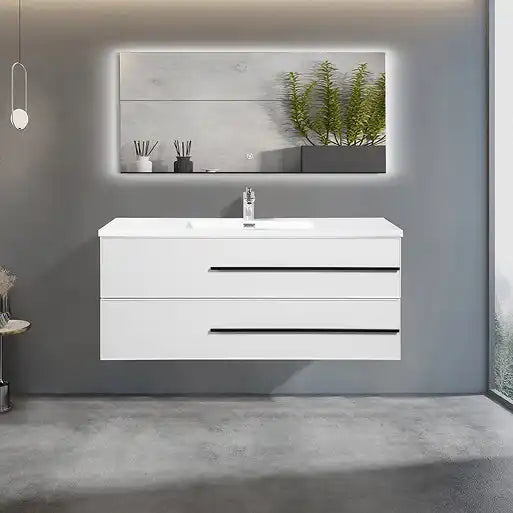 A modern white floating bathroom vanity with a single sink, a chrome faucet, and two drawers with black horizontal handles, positioned beneath a rectangular illuminated mirror.
