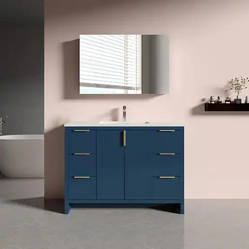 A navy blue bathroom vanity with a white countertop, a single sink, a mirror, and a combination of drawers and cabinets with gold-toned handles.