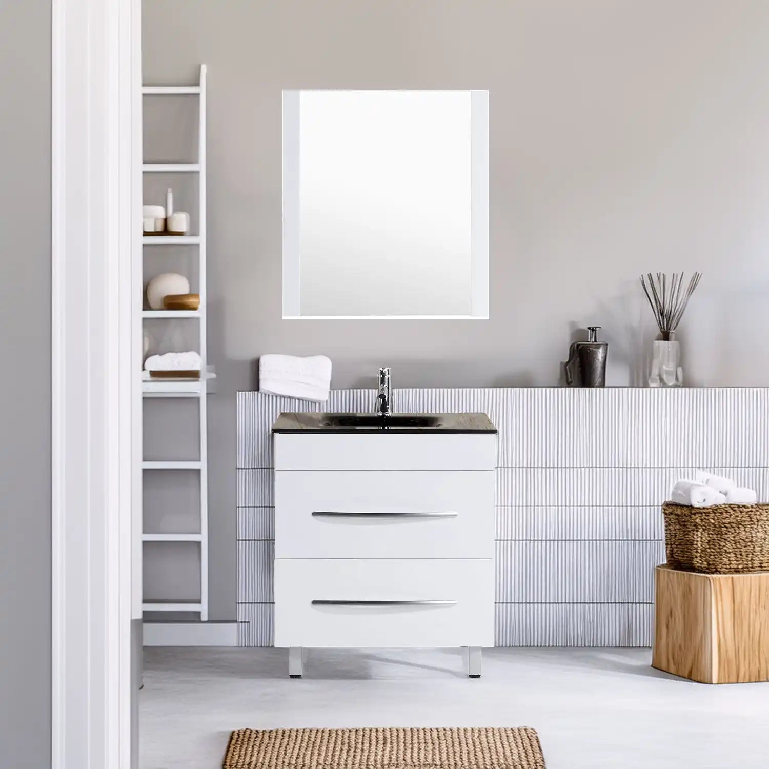 White bathroom vanity with a black countertop and sink, three drawers, and chrome handles.